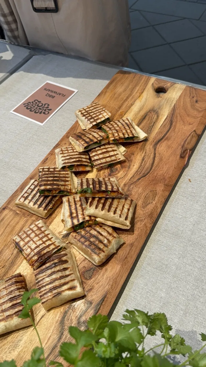 Sloppy Jo's flatwraps cut into quarter-sized finger-food pieces, arranged on a wooden tapas board