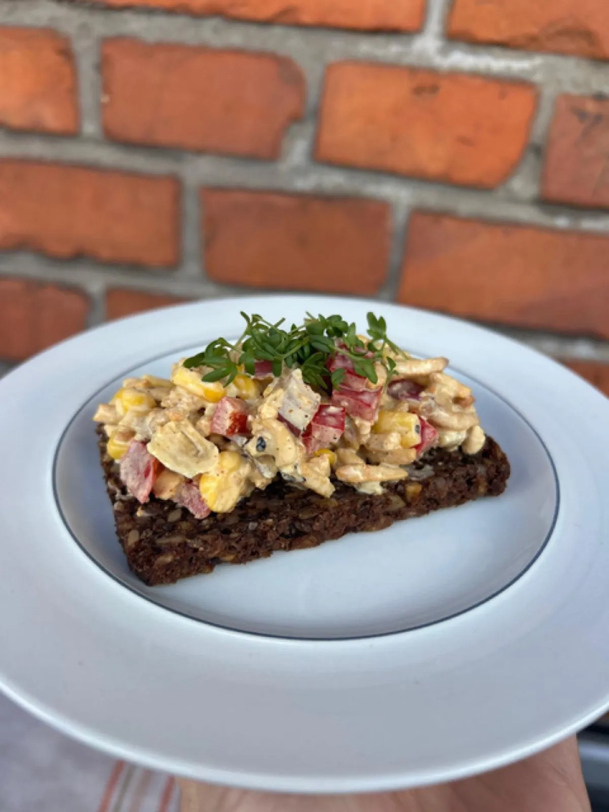 A pale-yellow curry salad with sweetcorn, red pepper cubes, red onion and Sloppy Jo's Basic Filling, plated on a board